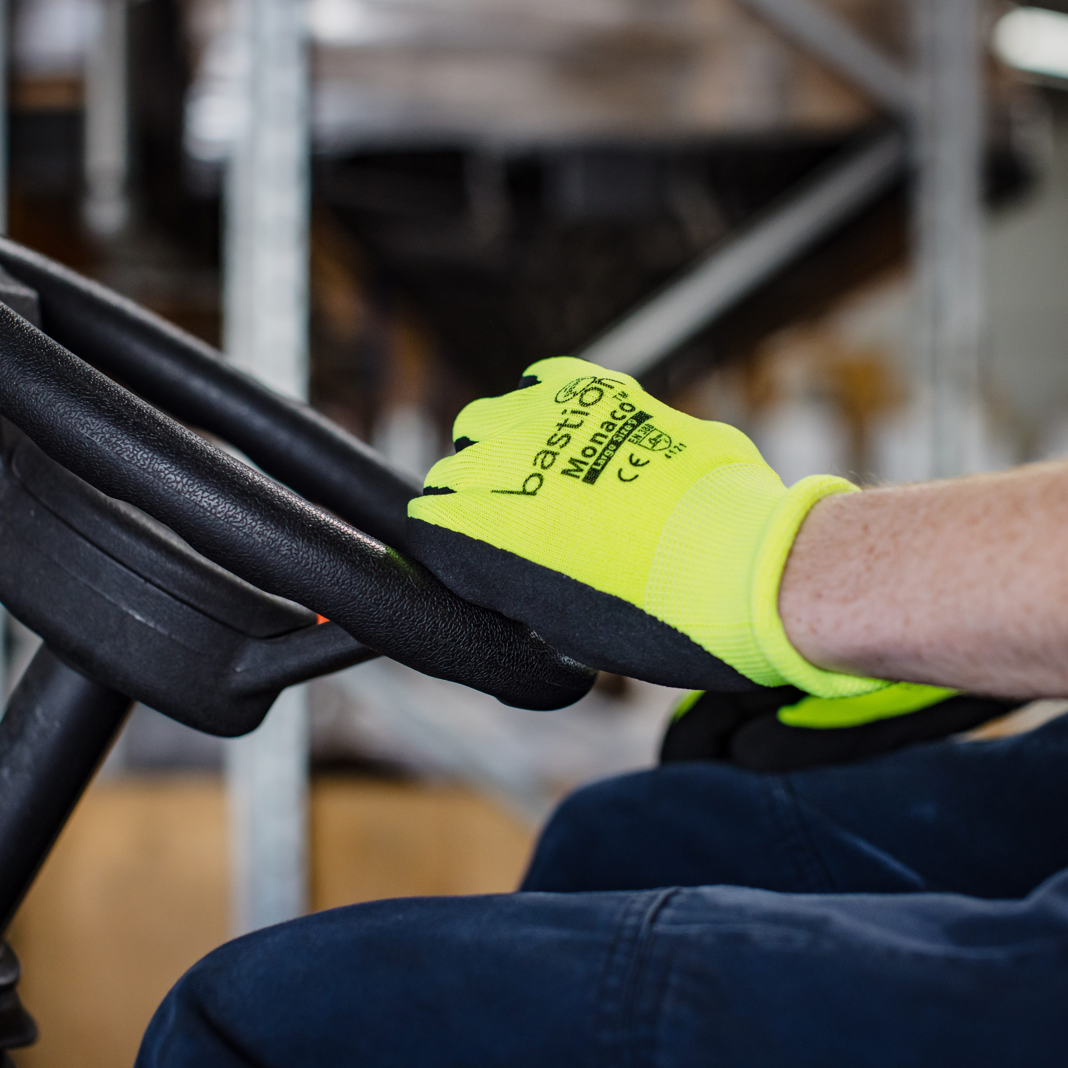 Bright yellow Monaco glove worn by forklift operator