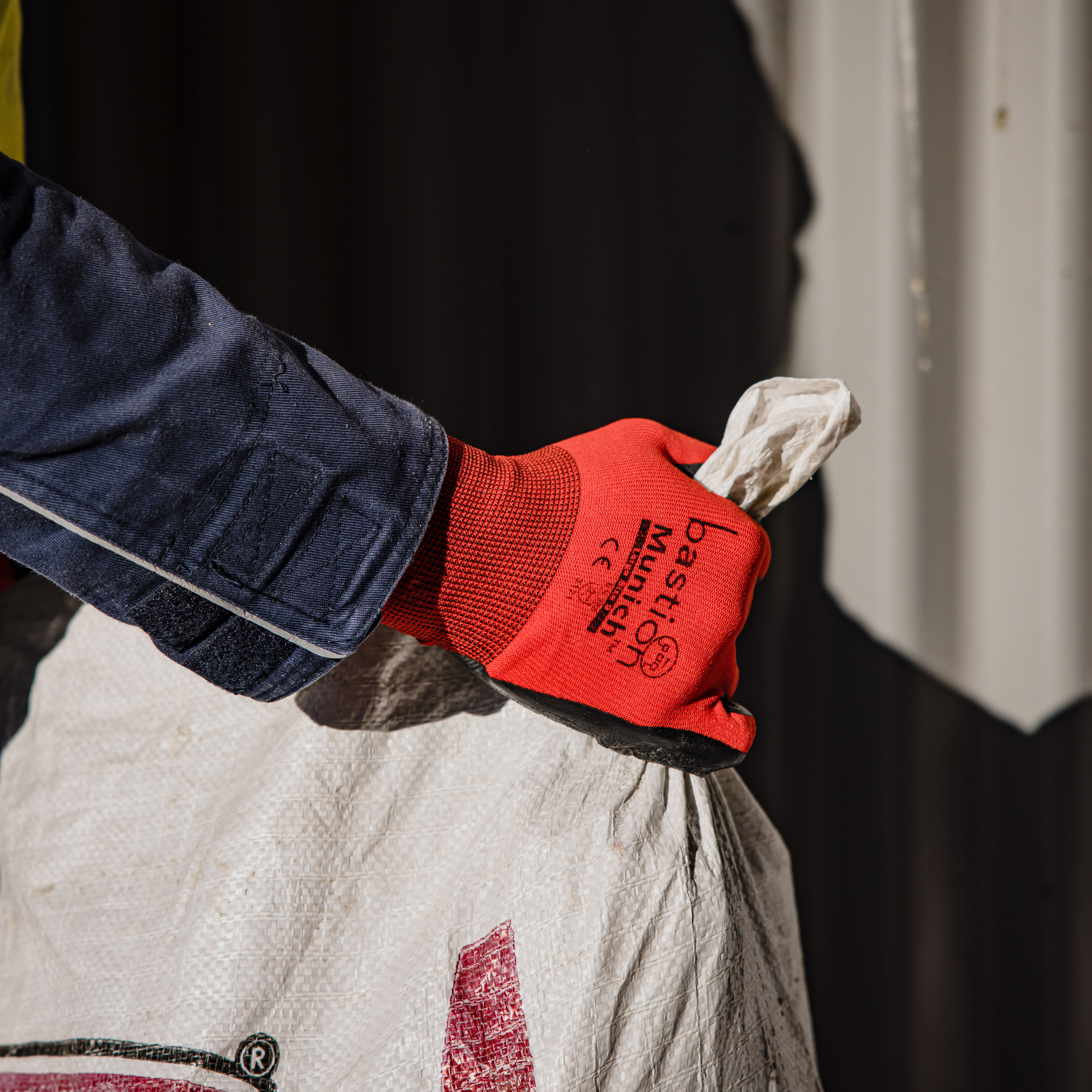 Bright red Bastion Munich gloves grabbing feed bag