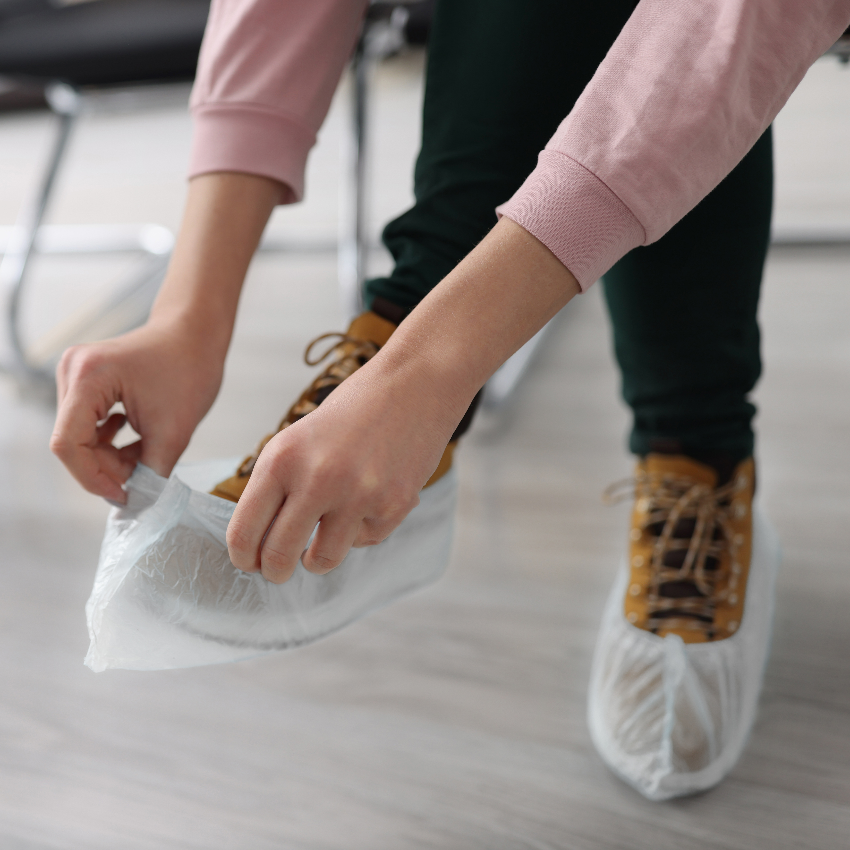 A lady putting on white over shoes
