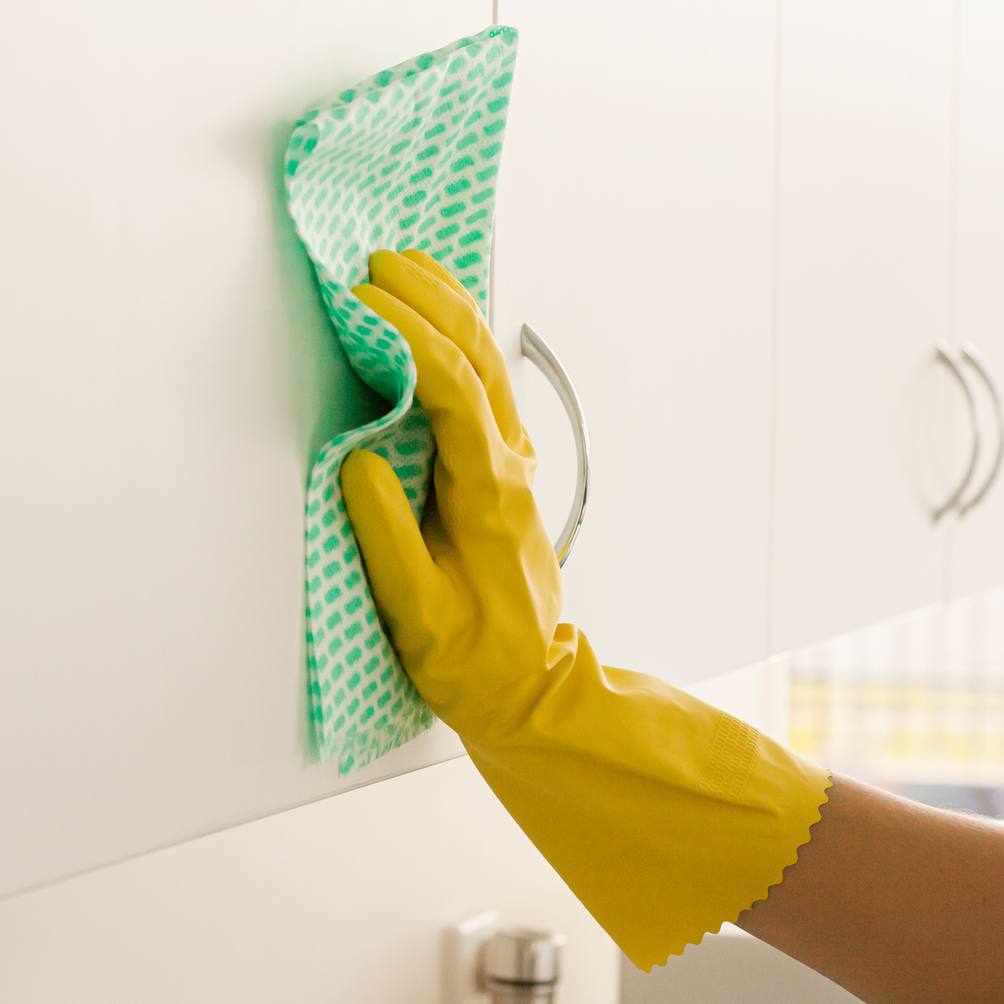 yellow silverlined gloves using green wipe to clean or wipe