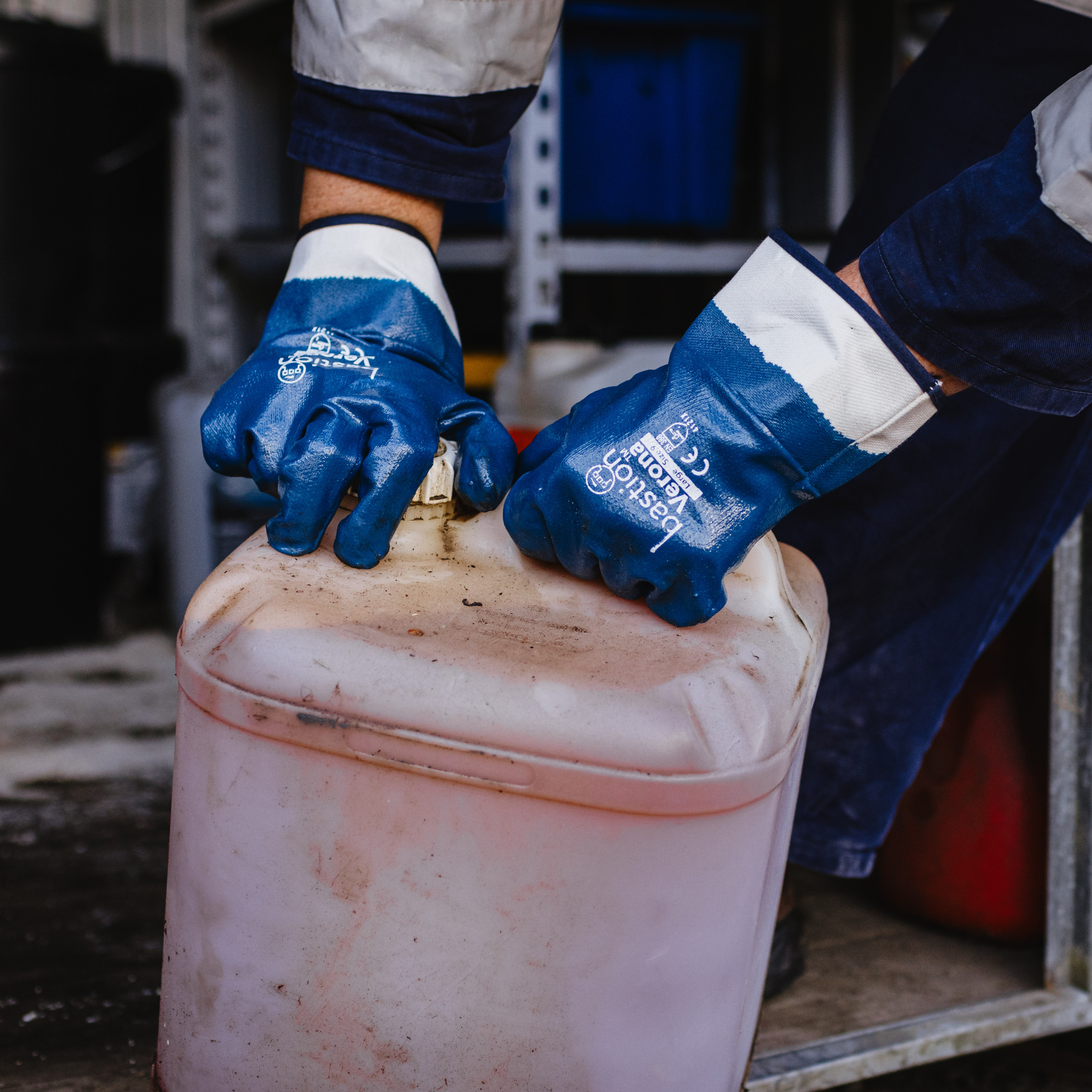 Close up of someone's hands wearing Bastion Verona Gloves opening a plastic container