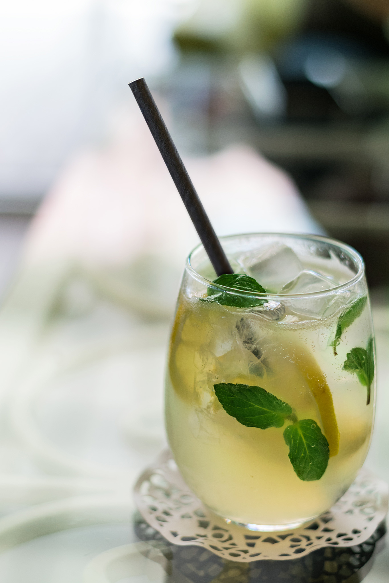 black paper straw in clear glass filled with a drink.