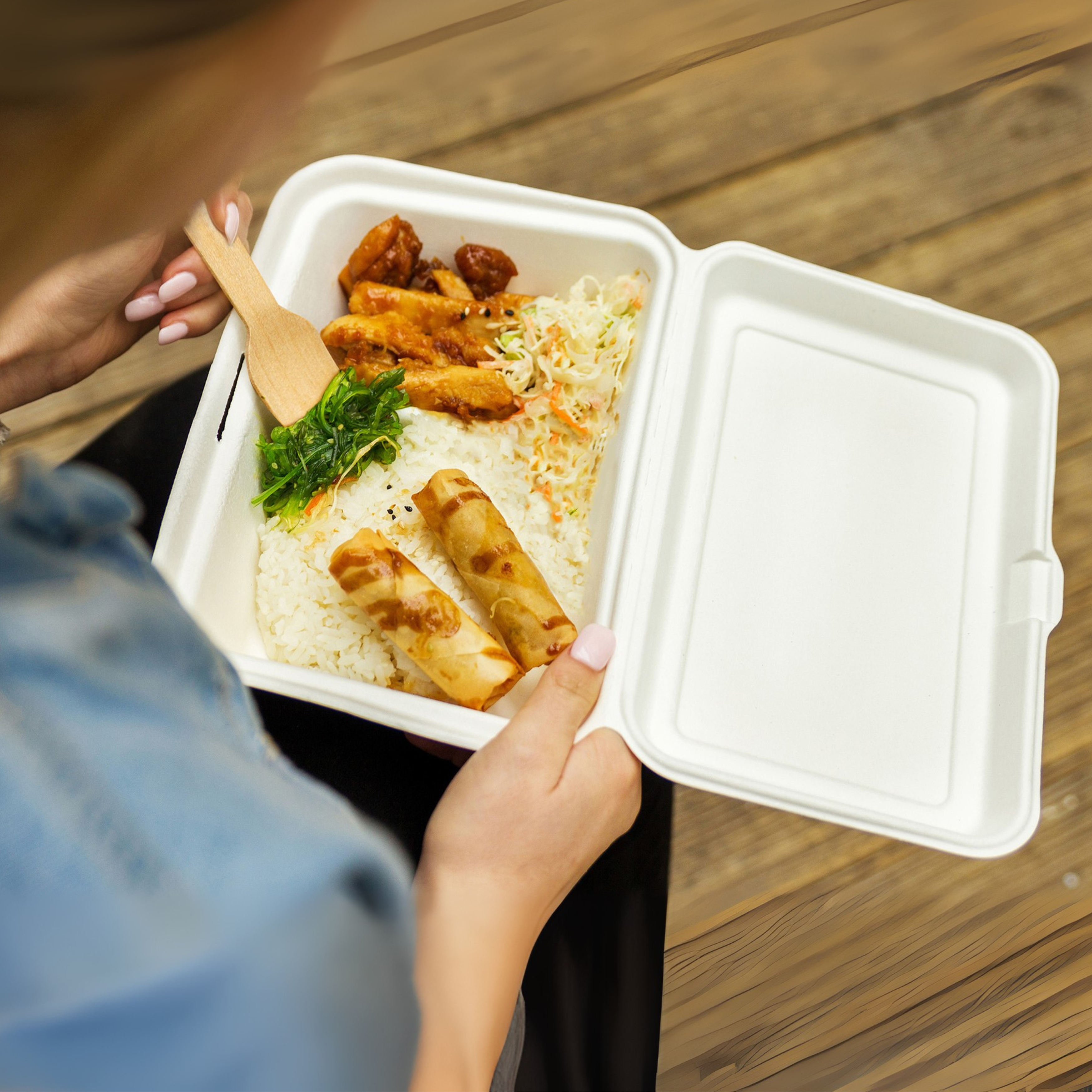A shot of a Green Choice sugarcane clamshell container filled of Japanese cuisine.