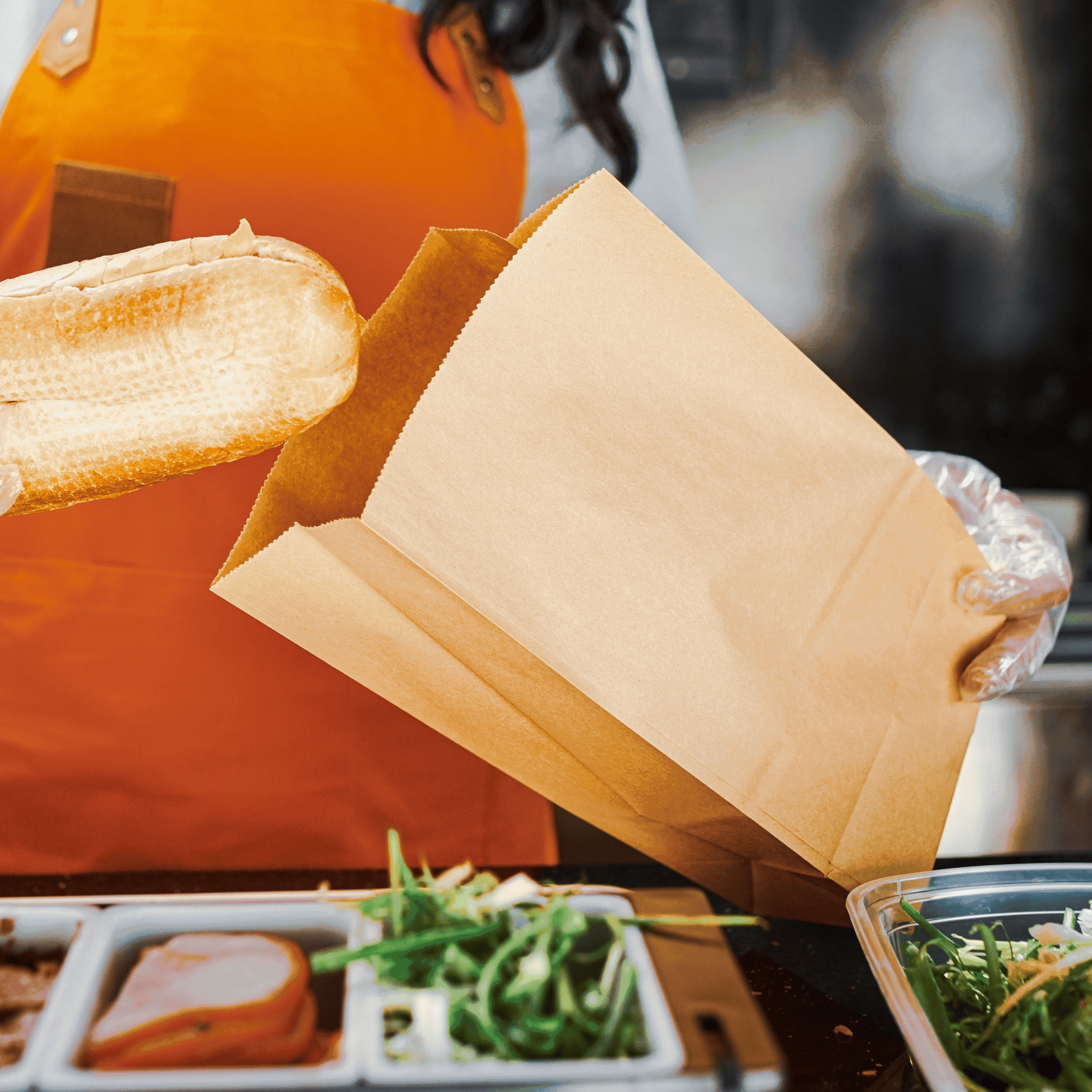 Someone is putting a filled roll into a block-bottom bag