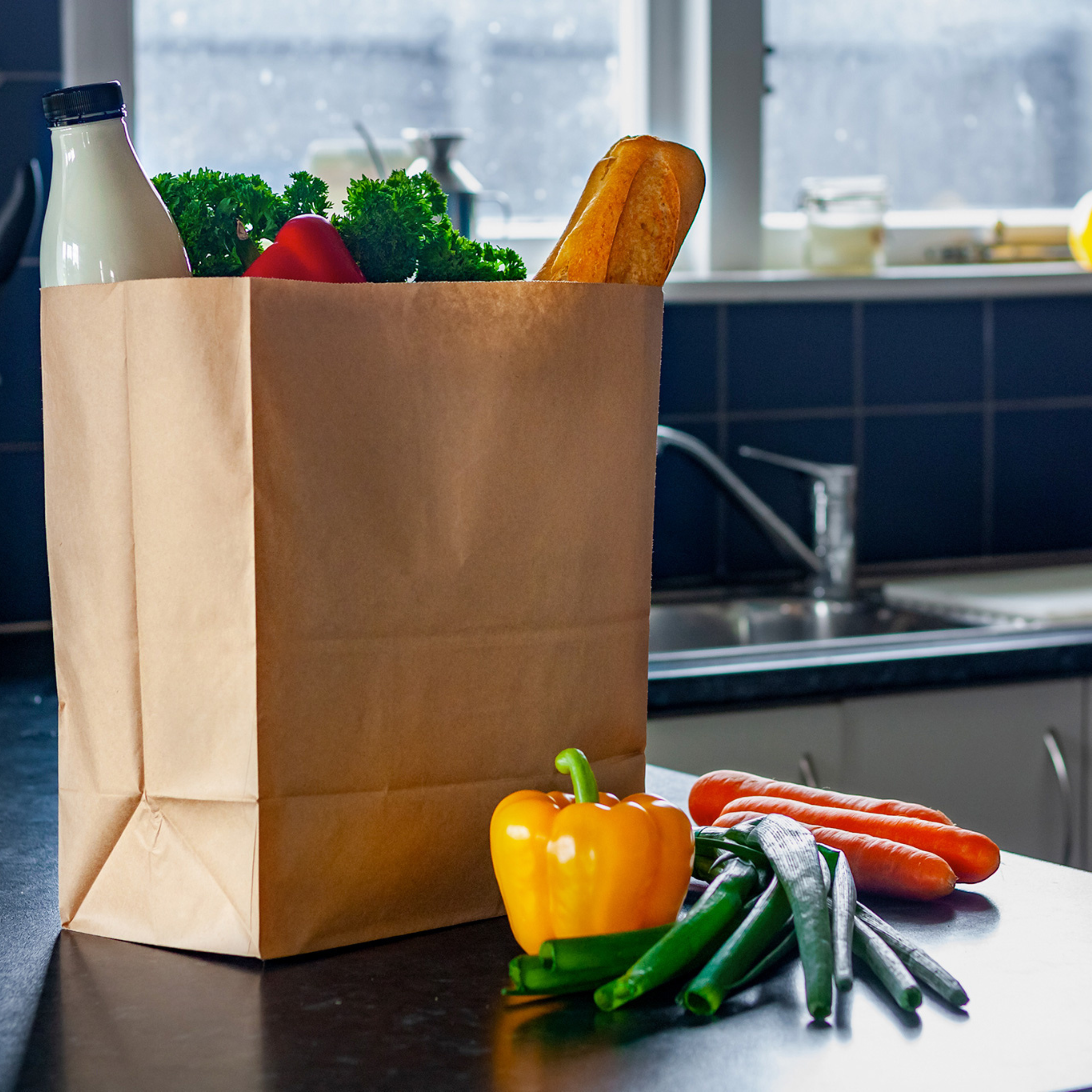 A Green Choice checkout bag sitting on a bench full of groceries