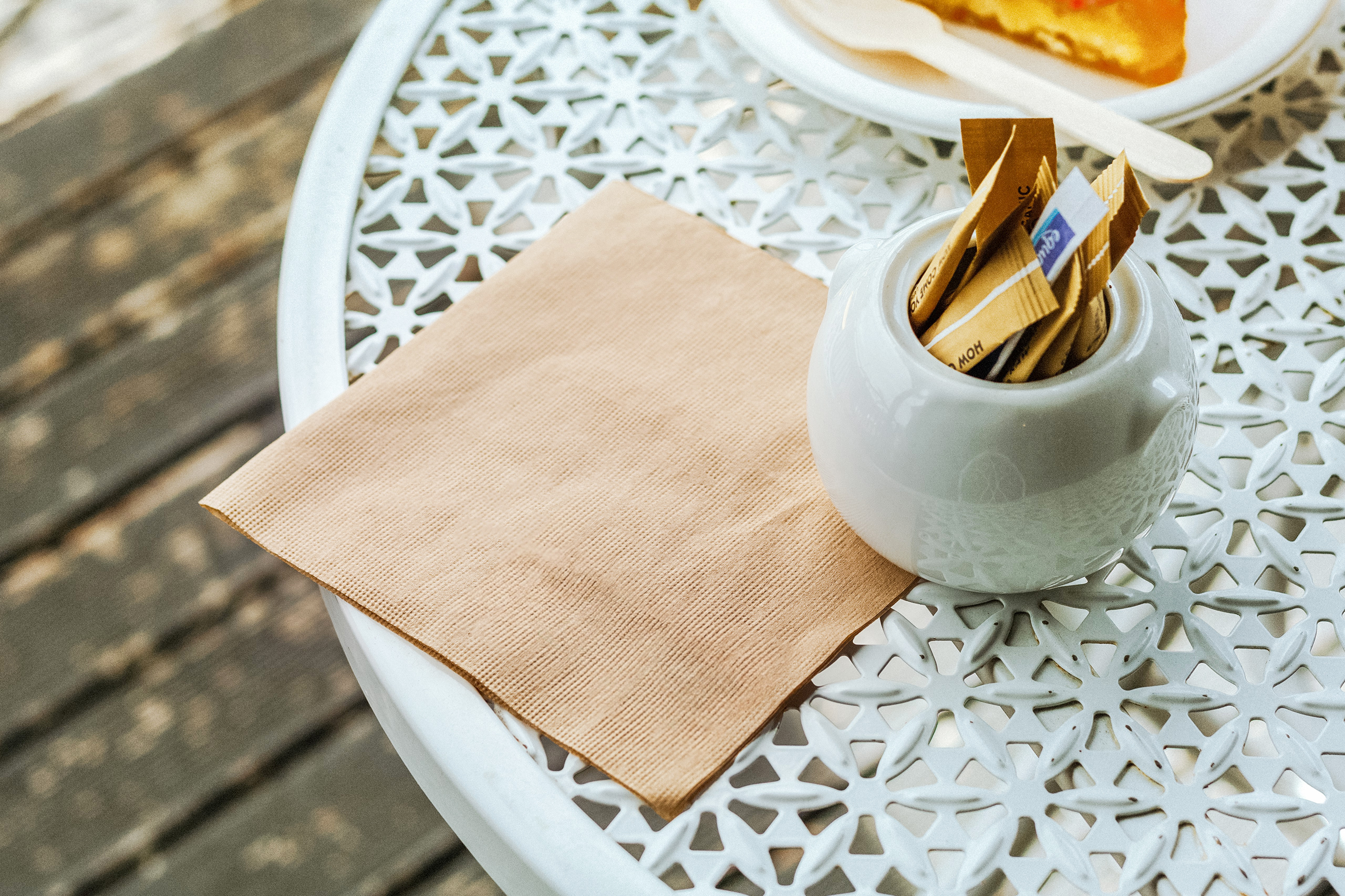 A close-up of a Green Choice kraft napkin sitting on a white cafe table