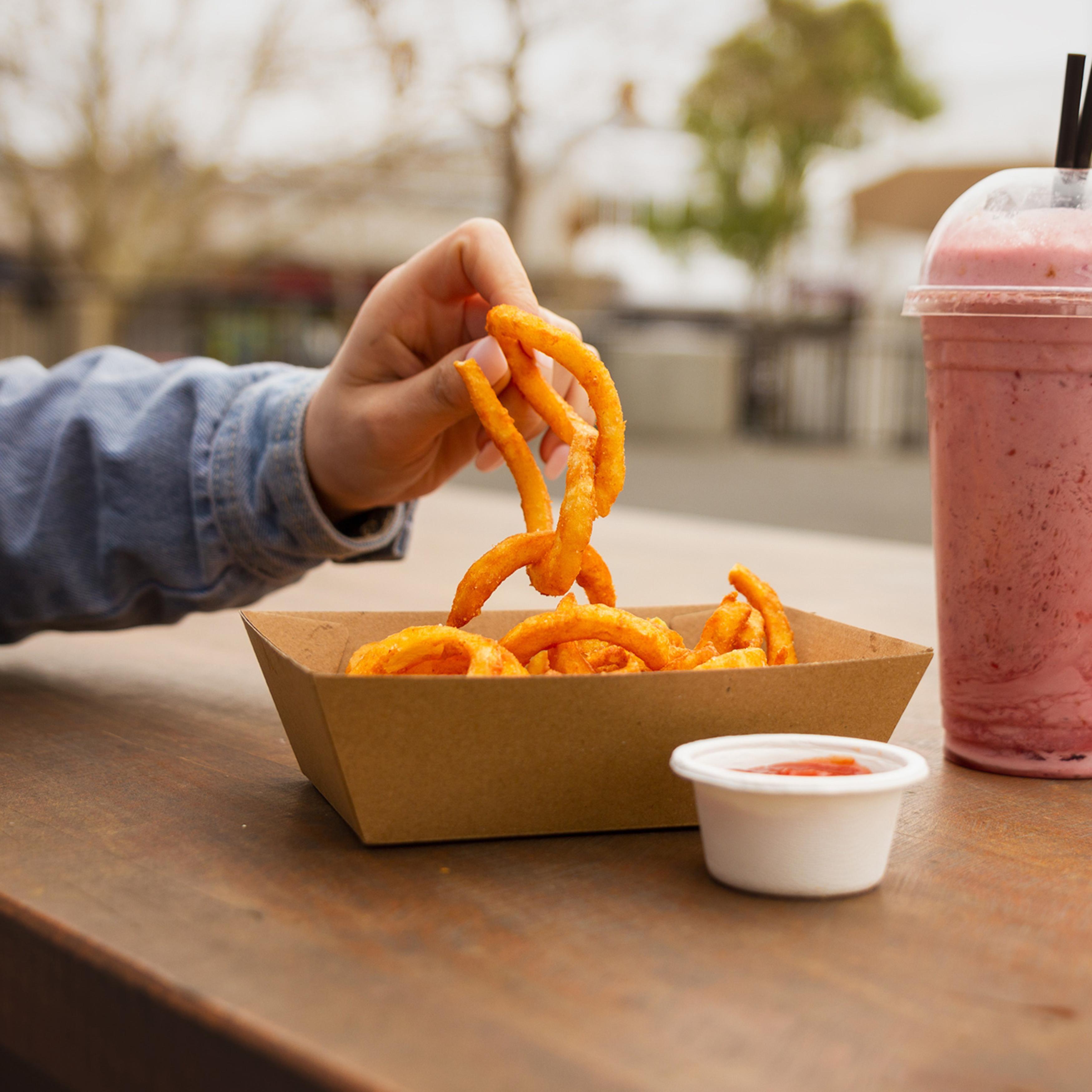 Someone is grabbing some hot chips from a Green Choice Corrugate Tray #1