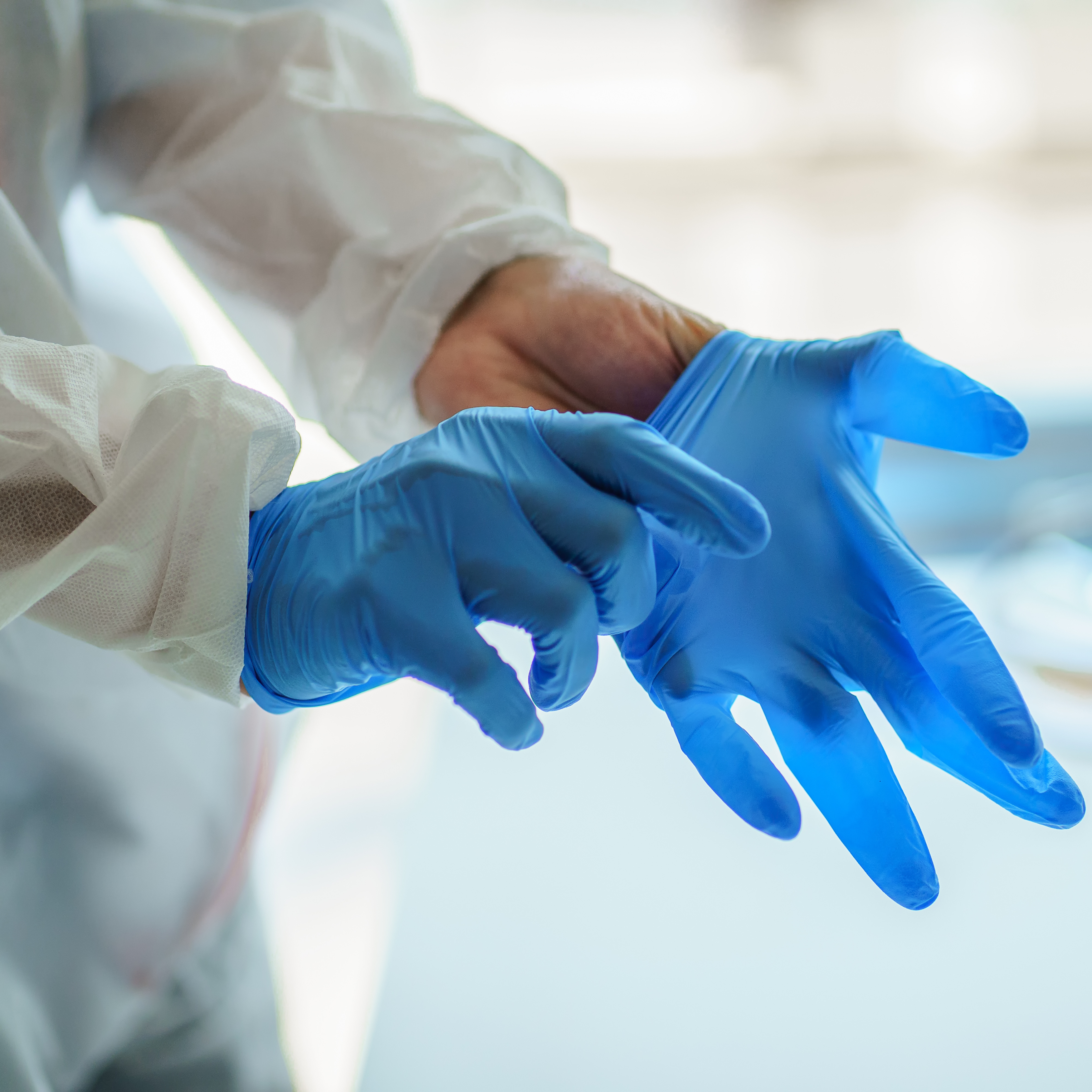 putting on nitrile soft blue gloves